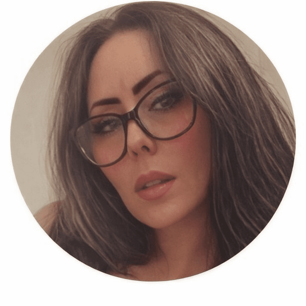 Circular portrait of a woman with long brown hair, large black glasses, and pink lipstick.